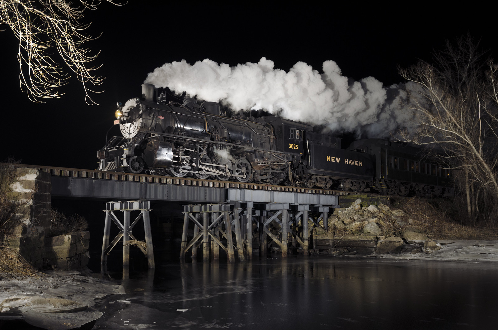 steam locomotive on a trestle at night